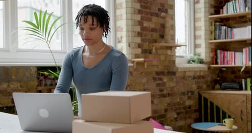 Young Adult Working on Laptop surrounded by Boxes