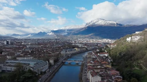 Aerial View of Grenoble City Center Showcasing the River Isere and Its Bridges and Snow Capped