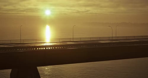 Majestic Sunrise Illuminating a Serene Bridge Over Calm Waters