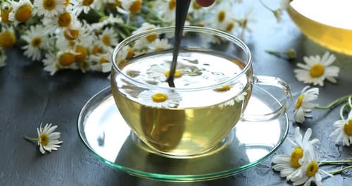Chamomile Tea Being Stirred with Spoon in Glass