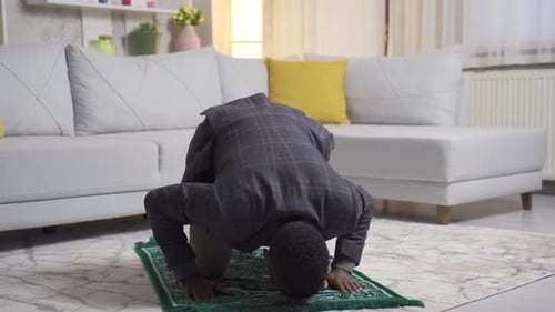 Jovem muçulmano africano orando em casa, adorando Alá.