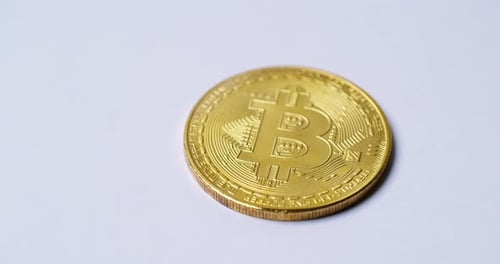 Close up the golden virtual coin with the bitcoin symbol isolated and rotated on white background. S