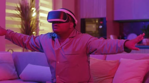 Man sitting on couch using virtual reality headset