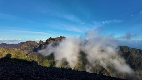 Scenic Mountain Range with Clouds Under Blue Sky