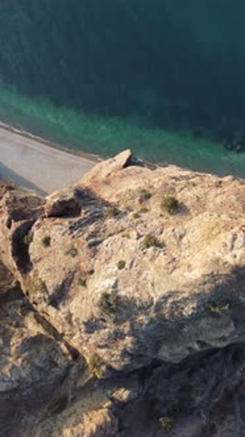 Aerial Vertical View of Beach with Wave Caressing Shore Sun Glare Small Waves on the Water Surface