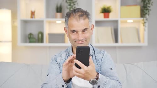 The man who happily puts the phone to his heart.