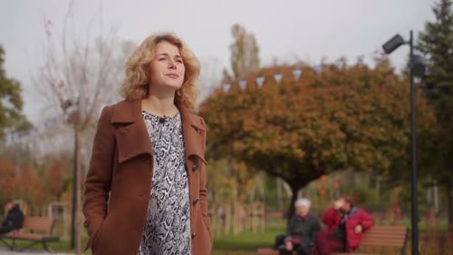 Elegant Woman Strolls in Autumn Park Vibrant Leaves Surround Smiling Lady Enjoys Fall Ambiance