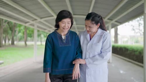Nurse Assists Senior Woman with Walk Therapy