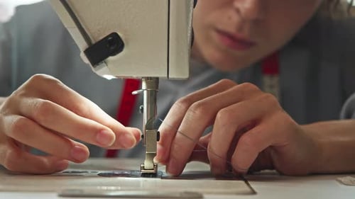 A Young Woman Prepares to Begin Her Embroidery Project at the Workshop By Inserting a Needle Into