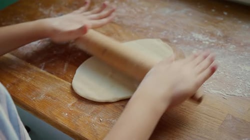 Child Rolling Dough with a Wooden Rolling Pin