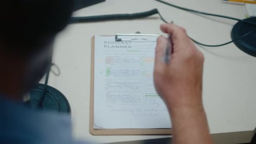 Host Filling Podcast Planner at Recording Studio