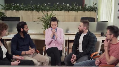 Group therapy office workers sitting in a circle and talking