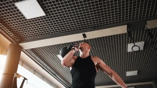 Hantel heben. Junger sportlicher, starker Mann in schwarzer Kleidung hat einen Trainingstag im Fitnessstudio