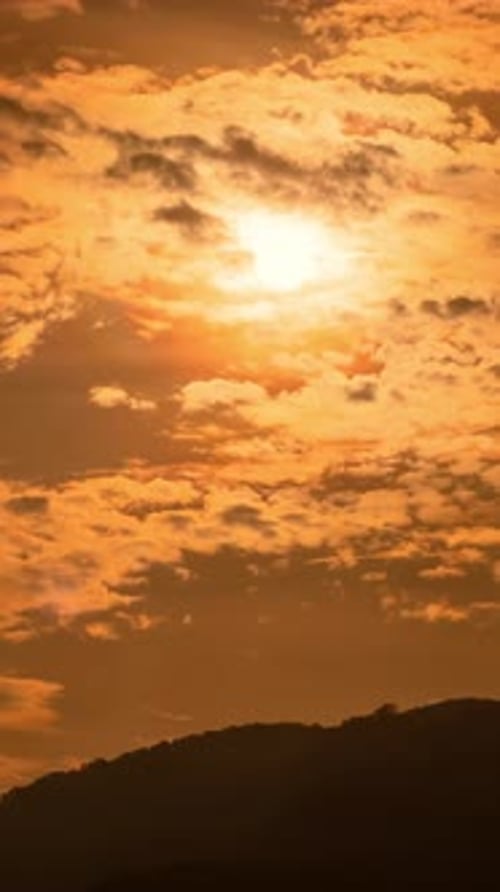 Timelapse d'un lever de soleil dramatique avec un ciel orange par une journée ensoleillée.