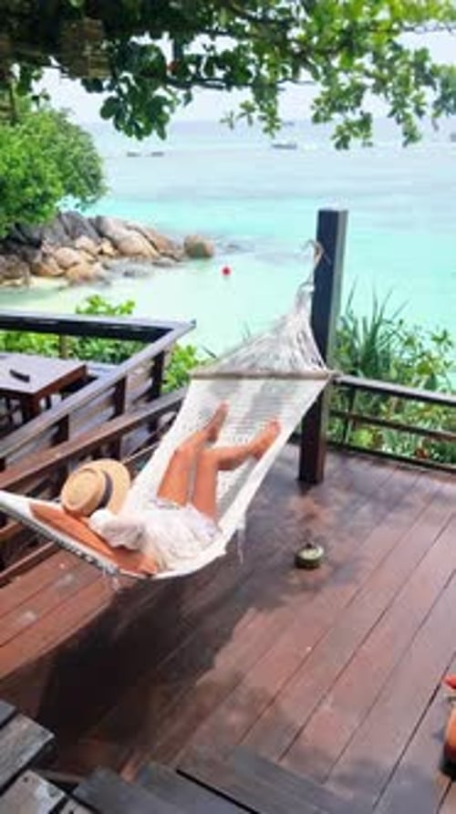 A Woman Relaxes in a Hammock on a Deck with a View of the Ocean Koh Lipe Thailand