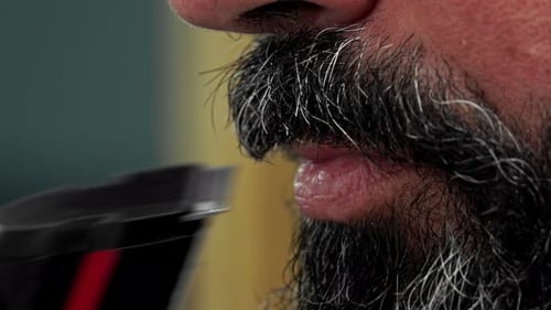 Adult Male Trims Beard With Electric Trimmer