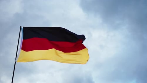 German Flag Flowing Against Cloudy Sky