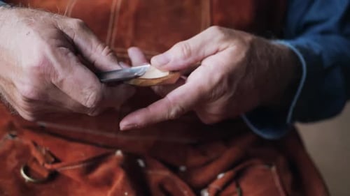 Man Crafting a Wooden Spoon with Knife Close-up