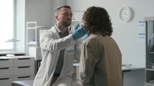 Doctor Examining Patient Neck in Medical Office