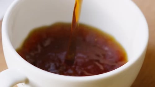 Fresh Morning Coffee Being Poured into White China Mug in Slow Motion