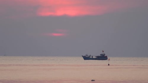 Filmansicht eines Fischerbootes, das in einer Dramatisch Abenddämmerung im Meer fährt