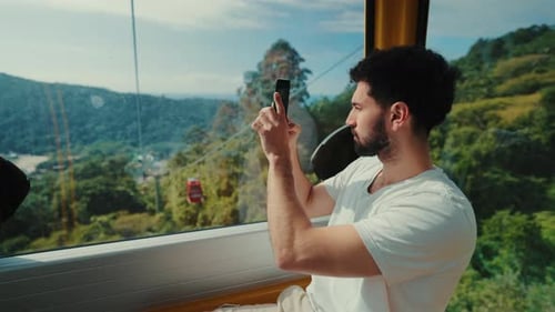 Young traveler captures scenic view from cable car ride in Balneario Camboriu, Brazil