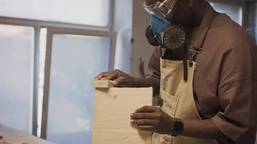Man Sanding Wood with a Sanding Block