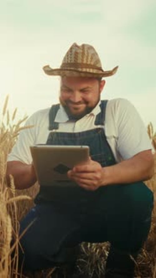 Cheerful Farmer Using Tablet in Golden Rye Field in Harvest Season Modern Technology in Agriculture