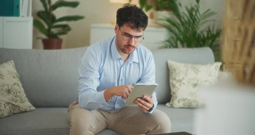 Man Works on App on Digital Tablet