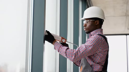 Construction Worker Sealing Modern Windows