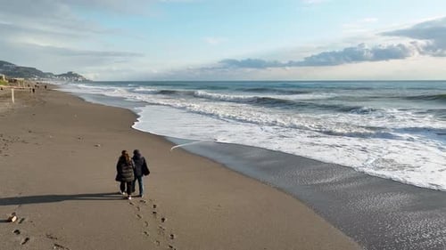 Middleaged Couple Walking on a Sandy Beach By the Sea or Ocean