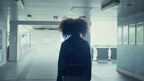 Back view - tourist African American woman walking on train station