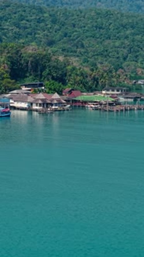 Aerial View of the Floating Wooden Houses of a Coastal Village on the Lush Island