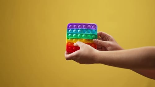 Adult Hands with Rainbow Pop It Fidget Toy