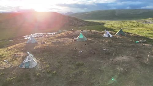 Mountain Campsite at Sunset with Teepees and Reindeer