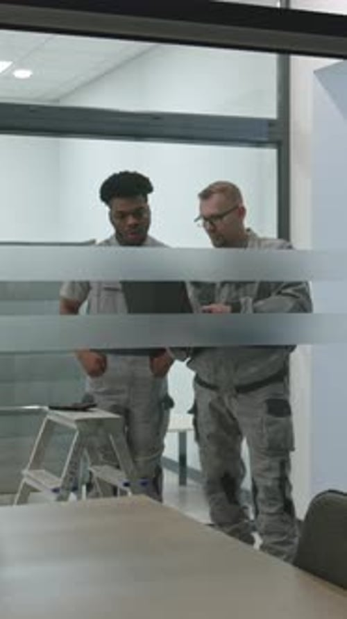 Workers Reviewing Tablet in Modern Office Environment