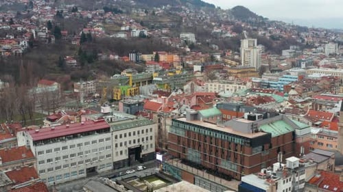 Aerial shot descending into a neighborhood in the city of Sarajevo on an overcast day.