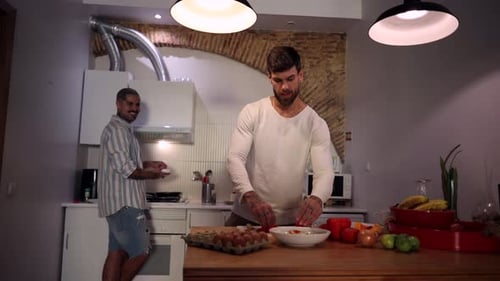 Two Men Preparing Food Together Indoors