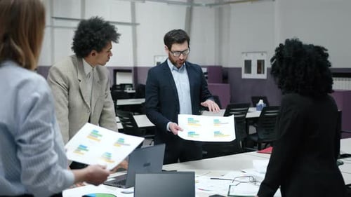 Caucasian and African American Men and Women Working in Modern Office Space