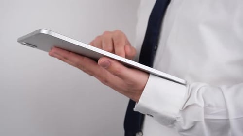 Man Uses Tablet in Business Attire