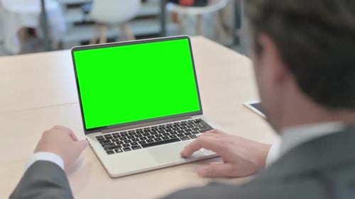 Businessman Working on Computer with Green Screen in Office