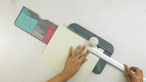 Hands crafting with paper and measuring tools