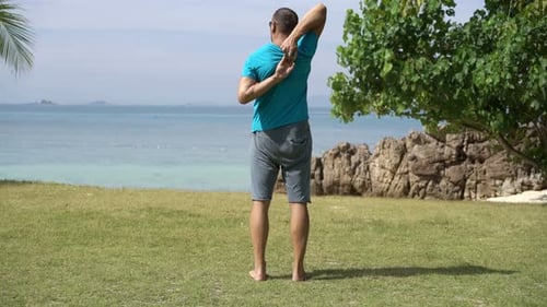 Young, Sporty Man Stretching Arms Near Sea Active