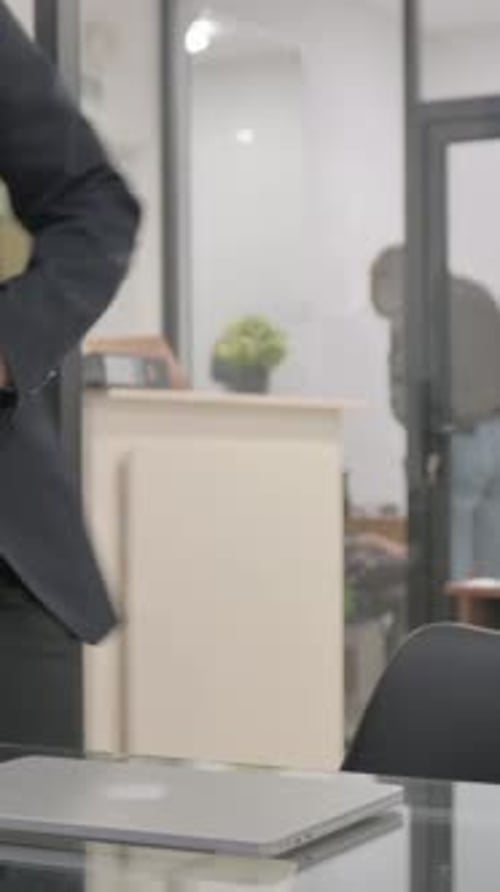 Kommendes Büro am Morgen und Öffnen des Laptops, vertikales Video