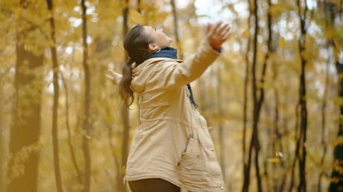 A Cute Girl Has Fun and Enjoys the Beauty of Autumn Leaves and Spins in the Park