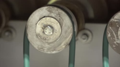 Industrial Metal Wheels Rotating with Green Belts