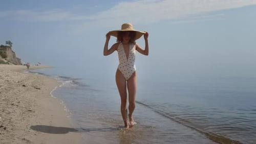 Posh Stylish Woman Walk on Warm Water Ocean Beach Covering Head With