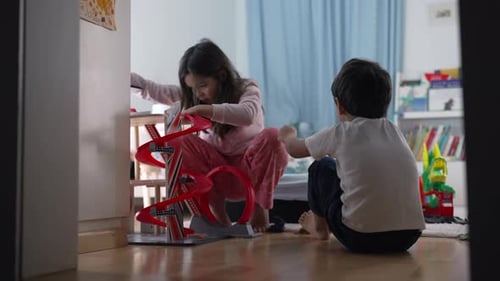 Brother and Sister Collaboratively Playing with Parking Lot Toy, Candid Bedroom Scene