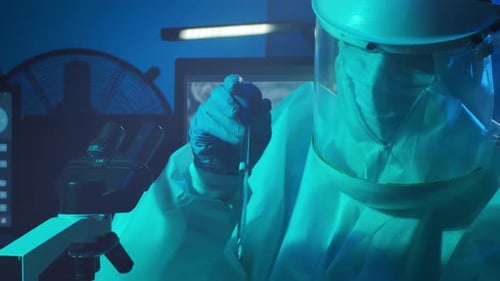 Researcher in Hazmat Suit Uses Microscope in Lab