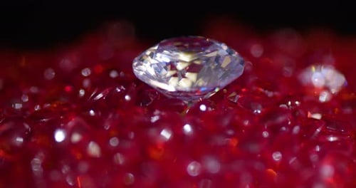 Big shiny real diamond surrounded by a heart shaped red stones spinning CCW close-up